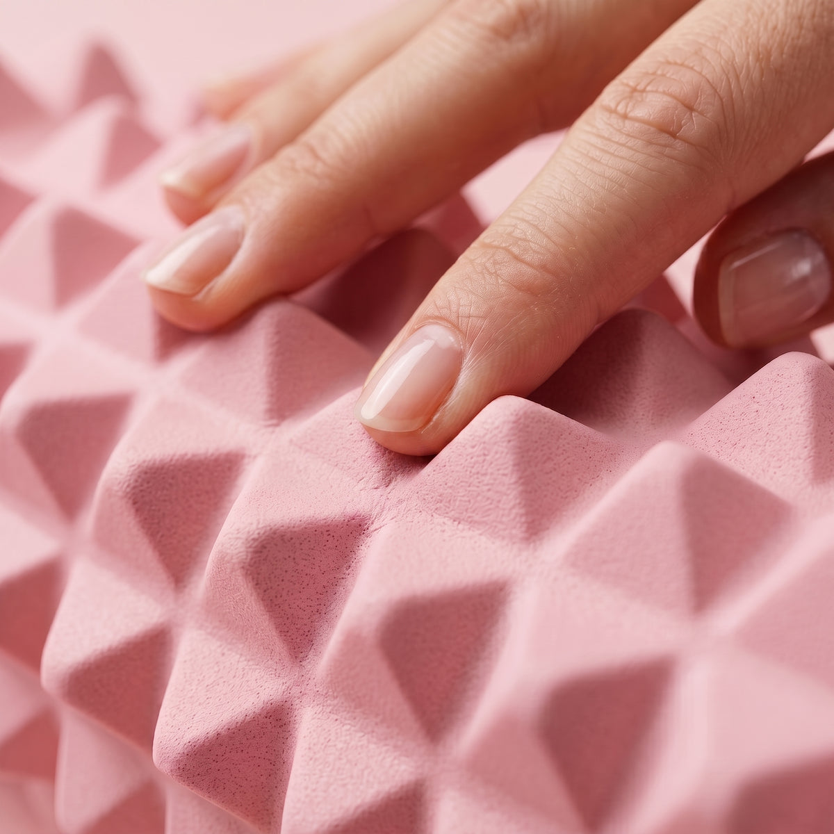 Gros plan sur le relief en pointes du rouleau de massage TriggeRoll rose