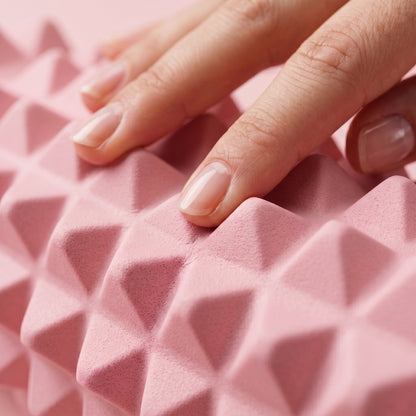 Gros plan sur le relief en pointes du rouleau de massage TriggeRoll rose